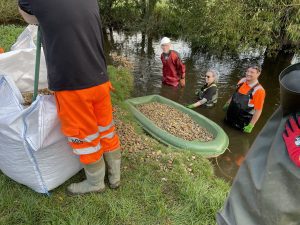 Volunteers prepare to install gravel into the River Whitewater 