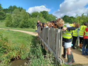 Children explore what's in the river and record their findings in a session led by the South East Rivers Trust on the River Mole © SERT