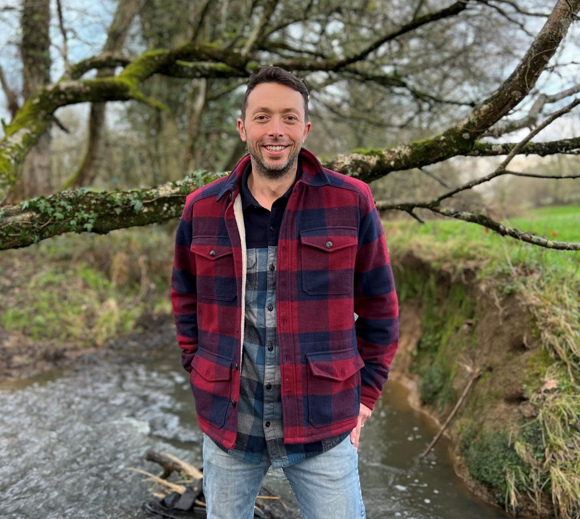 A man, Toby Hull, Head of Restoring Rivers and Catchments at the South East Rivers Trust, standing in front of a tree.