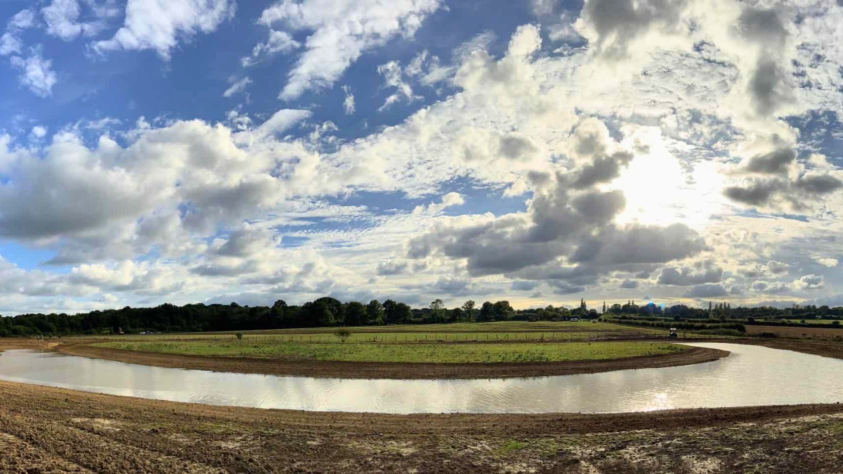 A large body of water in a field, forming flood plain restoration.