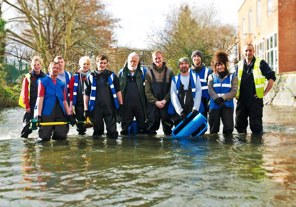 A group of people standing in water.