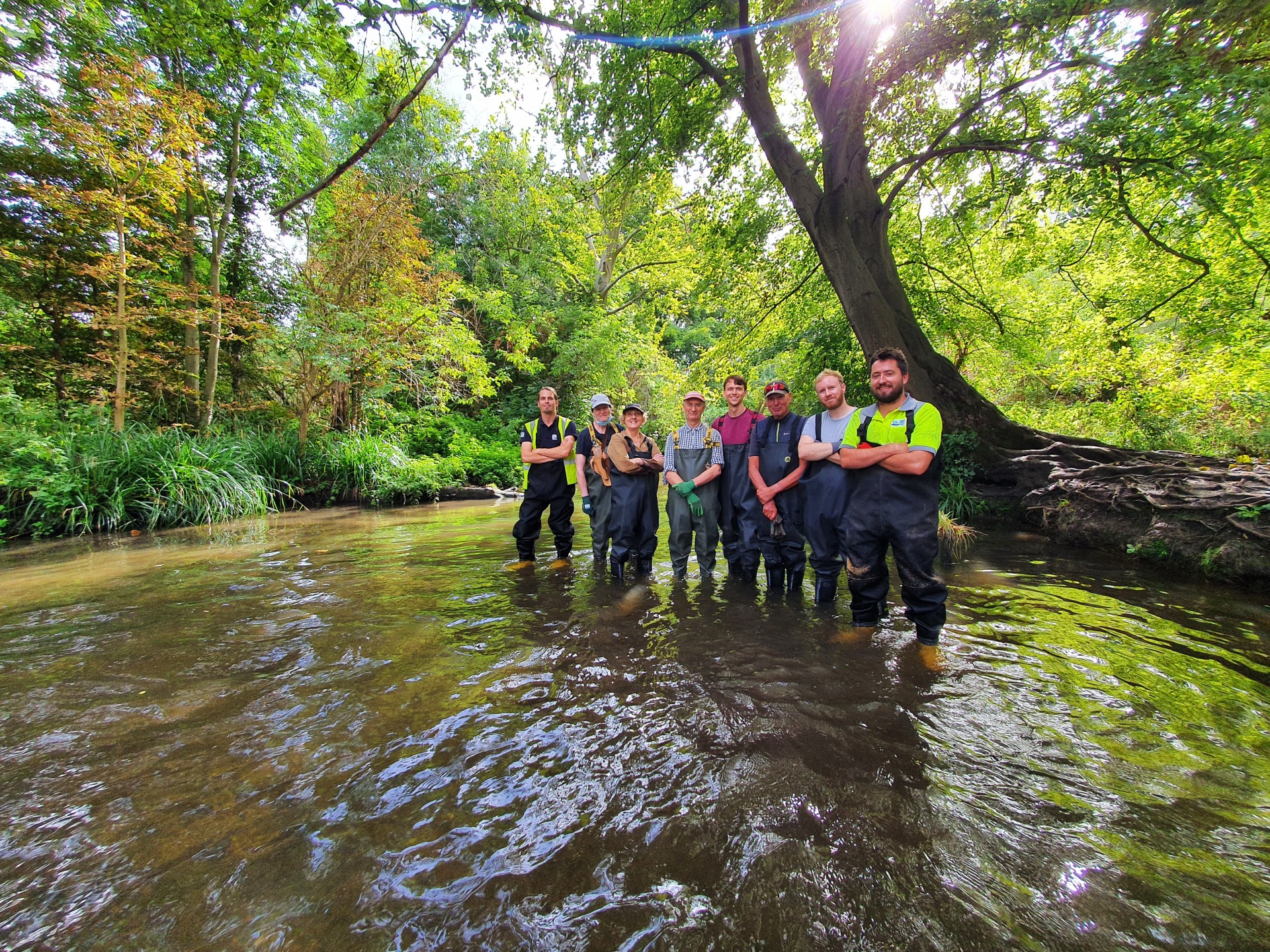 A group of people standing in a river.